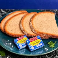 Tranches de pain de campagne avec deux portions de beurre demi-sel